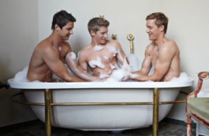 3 Gay Males naked in a bathtub. There is lots of suds