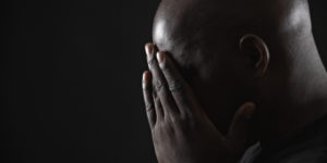 Mature man resting head in hands, side view