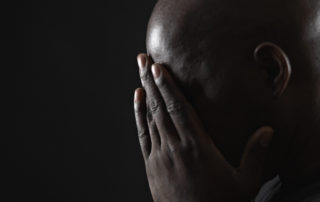 Mature man resting head in hands, side view